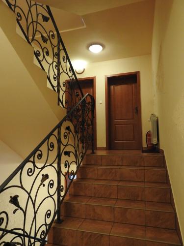 a staircase with a wrought iron railing and a door at U Juhasa Miętówka in Białka Tatrzanska