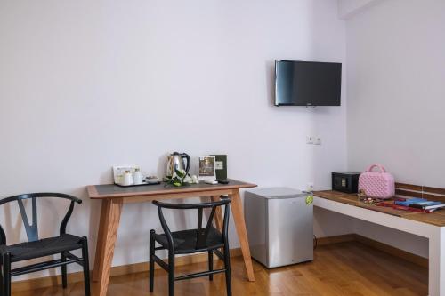 a room with a table and two chairs and a desk with a microwave at Lotus Inn in Athens