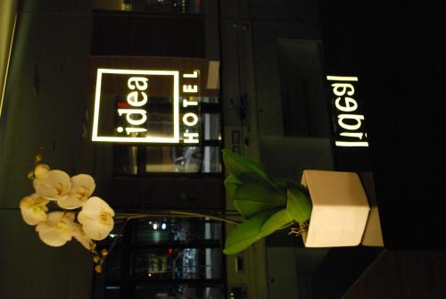 a vase of white flowers in front of a sign at Idea Hotel Plus Savona in Savona