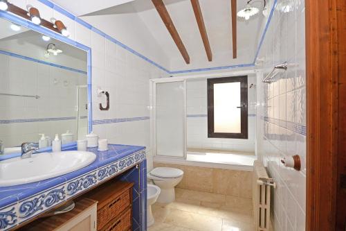 a blue and white bathroom with a sink and a toilet at Convent House in Alcudia