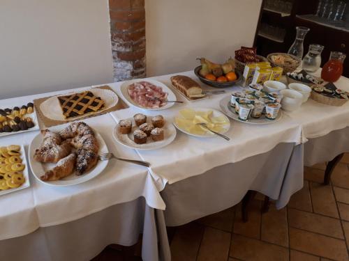 a table topped with plates of pastries and other foods at Agriturismo La Sapienza in Monestirolo
