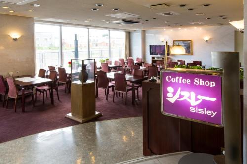 a restaurant with a coffee shop and tables and chairs at Oehonke in Kitami