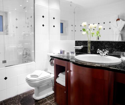 a white bathroom with a sink and a toilet at Eurostars Montgomery in Brussels