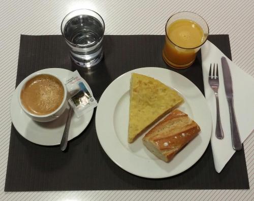 a table with a plate of food and a cup of coffee and toast at Hotel San Glorio in Santander