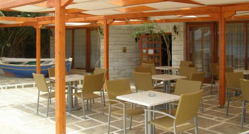 patio ze stołami i krzesłami oraz basenem w obiekcie Maistrali w mieście Livadion