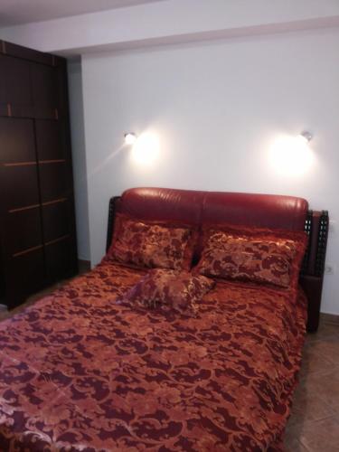 a bedroom with a red bed with two lights on the wall at Apartment Solinska Pot in Portorož