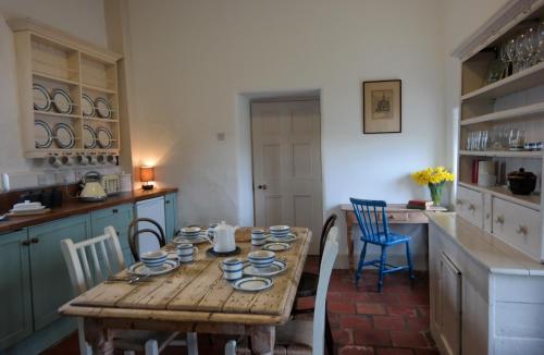 cocina con mesa de madera y sillas azules en Termon House, en Dungloe