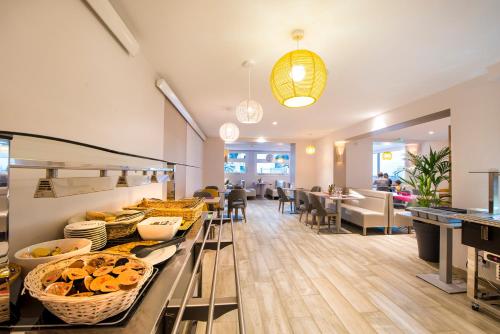 un restaurante con una línea de buffet con platos de comida en Villa Bettina, en La Baule