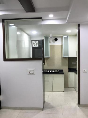 a kitchen with white cabinets and a clock on the wall at Hostmystay-3bhk Nehru place! Park in New Delhi