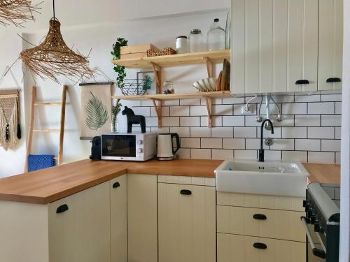 cocina con fregadero y microondas en Casa Azul, en Nazaré