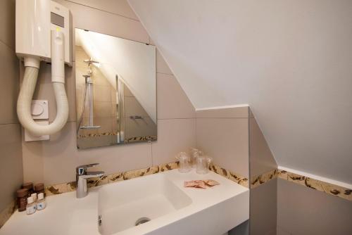 un baño con lavabo y espejo en Villa Bettina, en La Baule