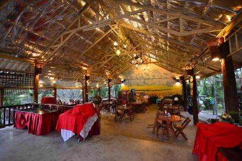 a restaurant with tables and chairs in a building at Touch Star Resort - Doi Inthanon in Chom Thong