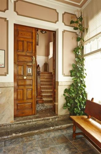 a wooden door in a house with a bench at Hotel Atalaya- FREE PARKING GRATUITO in Mundaka