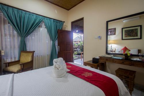 a bedroom with a bed with a towel animal on it at Masna House in Ubud