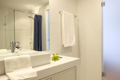 a white bathroom with a sink and a mirror at Lotus Inn in Athens