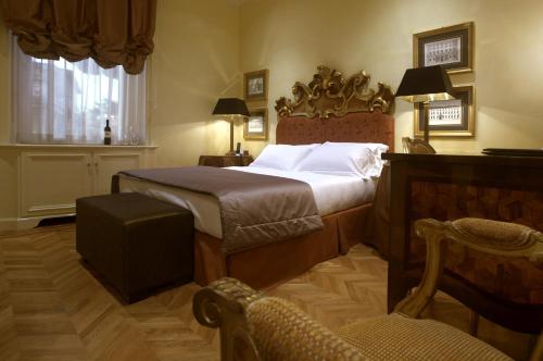 a bedroom with a bed and a chair and a window at Hotel Villa Duse in Rome