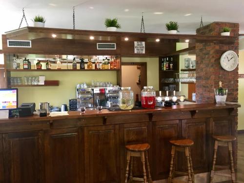 een bar met twee krukken en een klok aan de muur bij Restaurace Staré Sedlo in Orlík