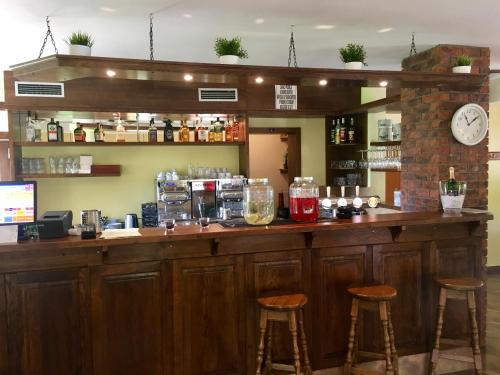 a bar with two stools and a clock on the wall at Restaurace Staré Sedlo in Orlík