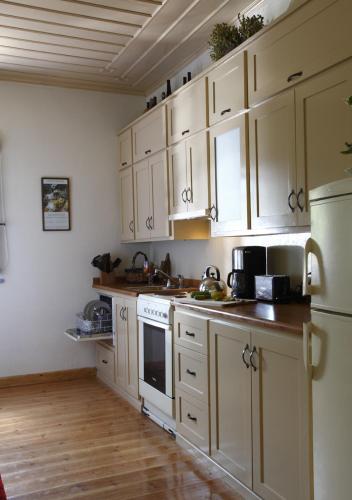 a kitchen with white cabinets and white appliances at Papigo Stonehouse in Papigko