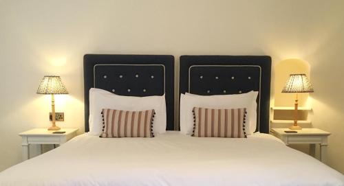 a bedroom with a large bed with two lamps at The Eagle House Hotel in Launceston