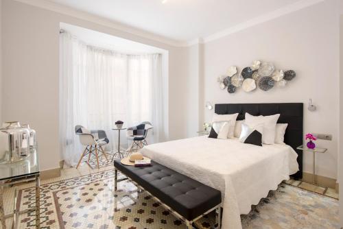 マラガにあるPiso Centro Malaga Excelente Ubicacion Nuevoの白いベッドルーム(大型ベッド1台、テーブル付)