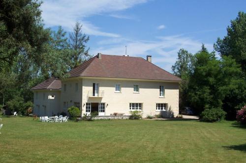 une grande maison blanche avec des tables et des chaises dans une cour dans l'établissement Domaine de Beauvilliers, à Chaumontel