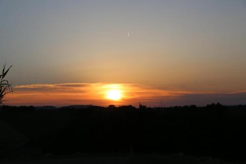 a sunset with the sun setting in the background at Casale Talevi in Cartoceto
