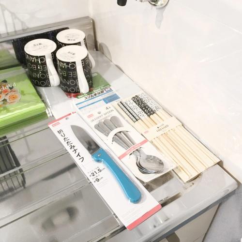 a drawer with a pair of scissors and other items at Guest House Fukuoka W101 in Kasugabaru