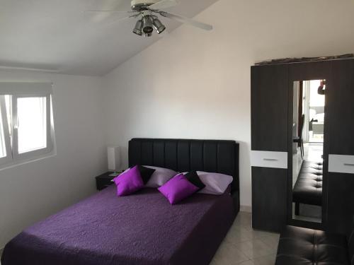ein Schlafzimmer mit einem lila Bett und lila Kissen in der Unterkunft Vila Nera in Zaboric