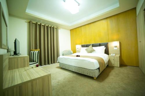 a hotel room with a bed and a television at Bzommar Palace Hotel in Harisa