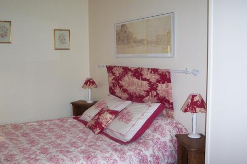 a bedroom with a pink bed with two lamps at Domaine de Beauvilliers in Chaumontel