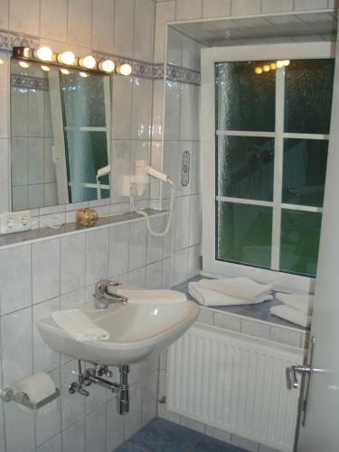 a white bathroom with a sink and a mirror at Landhaus Ferk in Unterburg am Klopeiner See