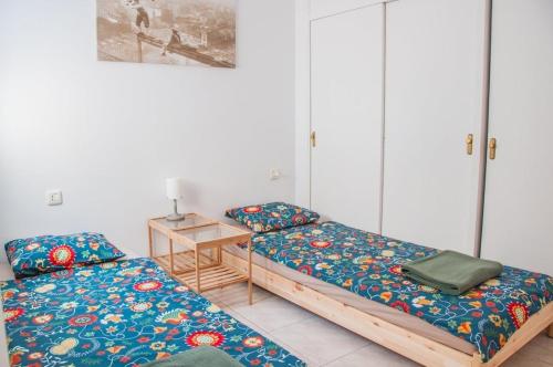 Cette chambre comprend 2 lits et une table. dans l'établissement Cozy vacation apartment in Los Gigantes, à Acantilado de los Gigantes