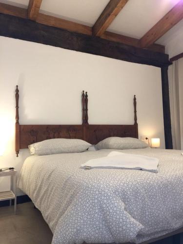 a bedroom with a large bed with a wooden headboard at Apartamentos Rurales Las Caleras in Almagro