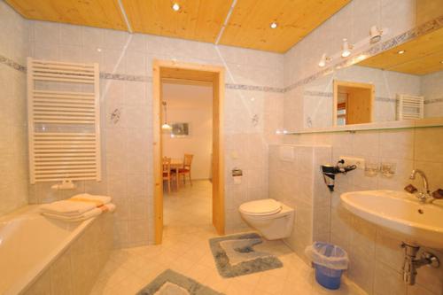 a bathroom with a tub toilet and a sink at Haus Rali in Sankt Anton am Arlberg