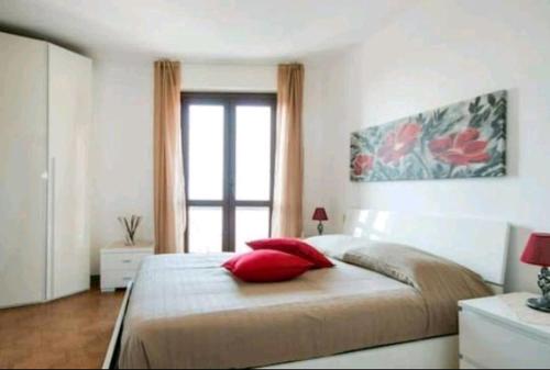 een slaapkamer met een groot bed met rode kussens bij House Carla in Bellano