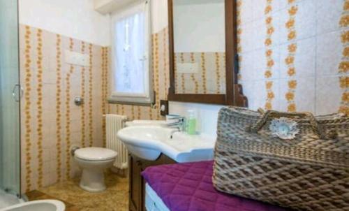 a bathroom with a sink and a toilet and a mirror at House Carla in Bellano