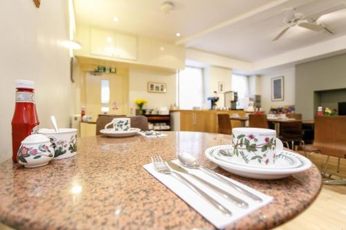 a table with plates and utensils on top of it at Jesmond Hotel in London