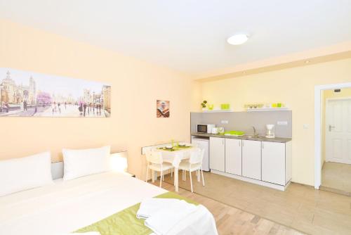Un dormitorio con una cama y una cocina con una mesa. en Central studio 1, en Burgas