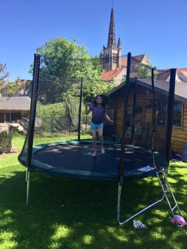 a girl is standing on a trampoline at Gîtelabaronnaise avec piscine chauffée prés parc Asterix in Baron