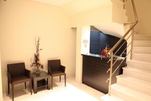 two chairs and a table in a room with a staircase at Hotel Niki in Nafpaktos