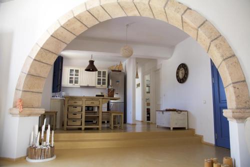 un arco en una cocina con mesa y barra en Luxury house in the island of Patmos en Grikos