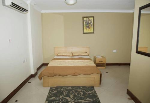 a bedroom with a bed and a rug at Ridge Over Suite in Accra