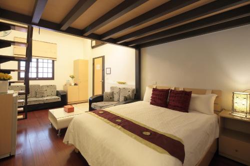 a bedroom with a large bed and a living room at Happiness Yes Hostel 2 in Luodong