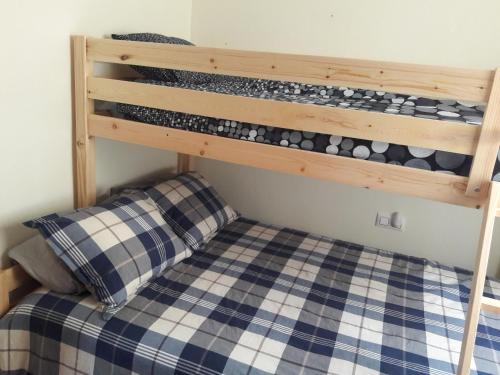 VillacostaにあるCarolinas aptmt Orihuelaの青と白のチェッカーベッドが備わるドミトリールームの二段ベッド1台分です。