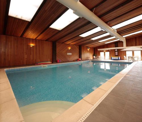 a large swimming pool in a building at Long Barn Holiday Cottages in Newton Abbot