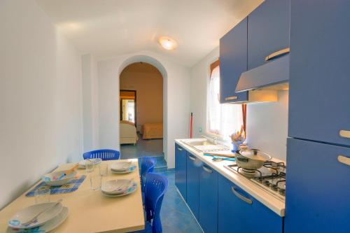 eine Küche mit blauen Schränken und einem Tisch mit blauen Stühlen in der Unterkunft Butterfly's House in Porto Recanati