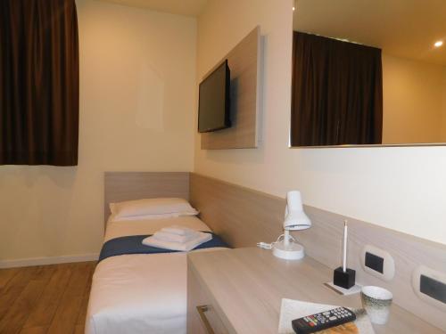 a hotel room with two beds and a television at Palace Hotel & SPA La CONCHIGLIA D' ORO in Vicenza