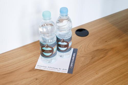 two bottles of water sitting on a box on a table at Coffee Fellows Hotel Dortmund in Dortmund