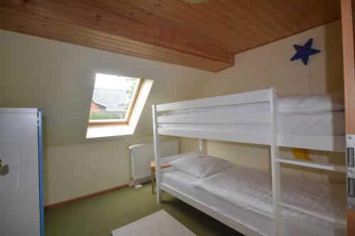 a bunk bed room with two bunk beds and a window at FerienGut Dalwitz Ferienhaeuser in Walkendorf